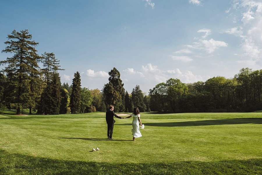 Brautpaar spaziert lässig auf Golfplatz von Schloss Kronberg