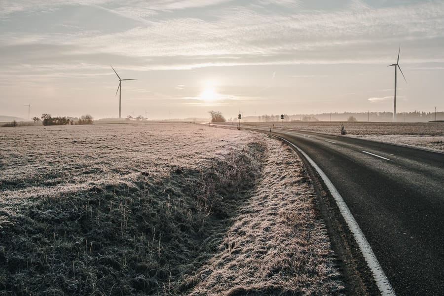 Landschaft im Winter mit Straße und Windgenerator